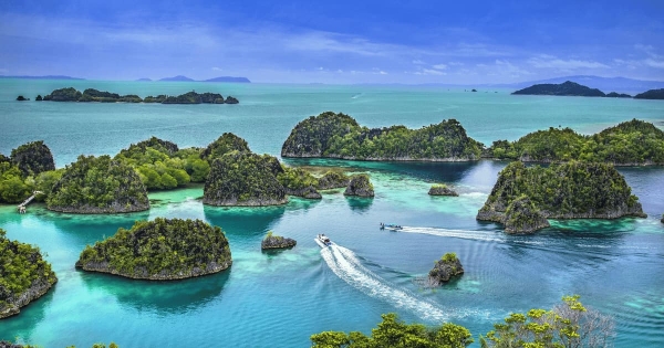 Scenic aerial view of Boracay Island’s turquoise waters and limestone islands in the Philippines, with boats gliding through the lagoon on a sunny day