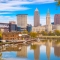 Cleveland skyline with buildings reflecting on the Cuyahoga River in Ohio.