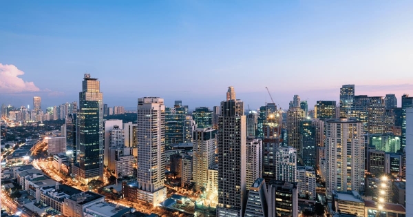 The vibrant skyline of Manila, Philippines, glows as dusk settles