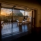 St. Lucia Sunset Balcony View – Wooden deck with chairs overlooking the Pitons and Caribbean Sea at sunset.