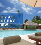 Luxury poolside at Serenity at Coconut Bay resort in St. Lucia with sun loungers and tropical palm trees.