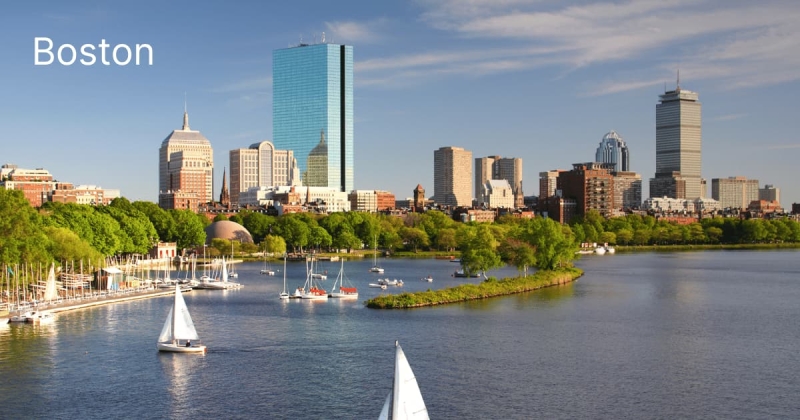 Boston skyline view with sailboats on the Charles River during a sunny day in Massachusetts