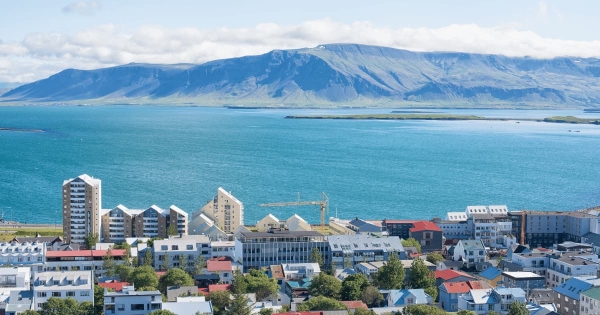 Reykjavik cityscape with colorful houses, modern buildings, and mountain view across Faxaflói Bay in Iceland.