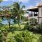 Luxury St. Lucia Oceanfront Villa – Tropical garden with palm trees and sea view from a Caribbean villa.