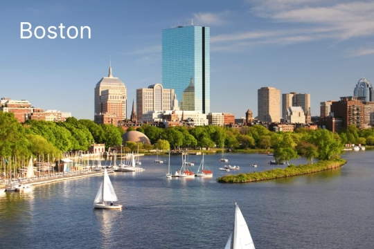Boston skyline view with sailboats on the Charles River during a sunny day in Massachusetts