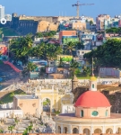View of San Juan, Puerto Rico, with coastal fort, colorful houses, and dome of Santa María Magdalena de Pazzis Cemetery.