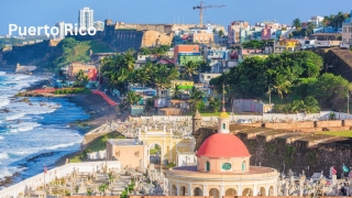View of San Juan, Puerto Rico, with coastal fort, colorful houses, and dome of Santa María Magdalena de Pazzis Cemetery.