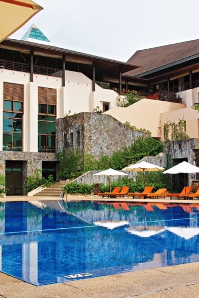 Luxury resort with outdoor pool, lounge chairs, and umbrellas.
