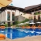 Luxury resort with outdoor pool, lounge chairs, and umbrellas.